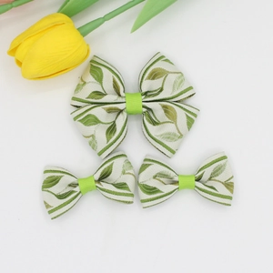 Detailed view of 3-piece floral jacquard bow hair clips with green leaf patterns