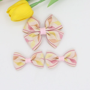 Detailed view of jacquard floral bow hair clips set with pink leaf patterns