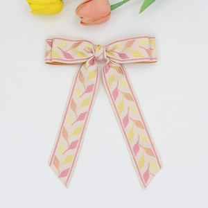 Elegant white ribbon bow hair clip with embroidered leaf patterns and flowing streamers