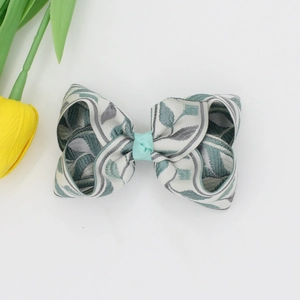 Détail du nœud papillon multicouche avec motifs de feuilles en jacquard gris et bleu