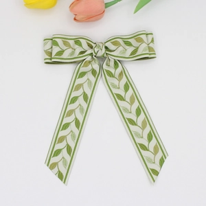 Detail of green leaf pattern jacquard bow hair clip with elegant long ribbons