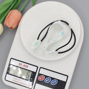 White daisy lace embroidery hair band weighing 6g on a digital scale for girls