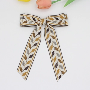 Detailed view of the vintage jacquard leaf pattern on the multi-layered bow hair clip