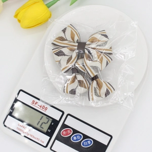 Three-piece ethnic jacquard bow hair clip set for girls with gold and brown leaf patterns