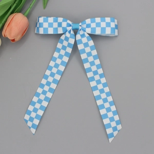 Barrette à cheveux avec nœud à carreaux bleu et blanc et longs rubans sur fond gris