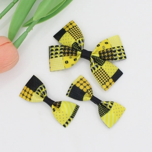Detail of yellow and black grosgrain ribbon hair bows with mixed geometric patterns