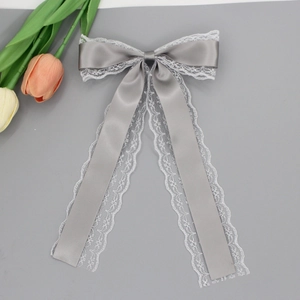 Vue détaillée d'une pince à cheveux en satin gris avec dentelle blanche et longs rubans