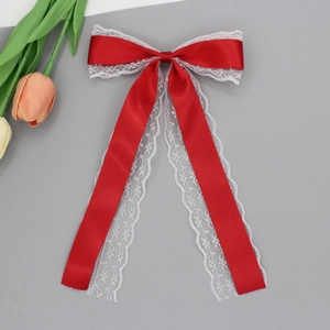 Gros plan détaillé d'un nœud papillon en satin rouge avec dentelle blanche et longs rubans