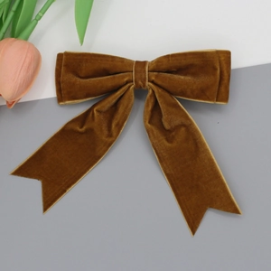 Detail view of caramel velvet bow hair clip with elegant swallowtail ribbon ends