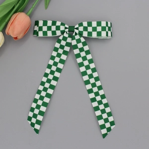 Détail d'un nœud papillon à carreaux verts et blancs avec de longs rubans gros-grain