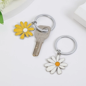 Detail shot of yellow and white daisy keychains with polished metal rings and flower charms
