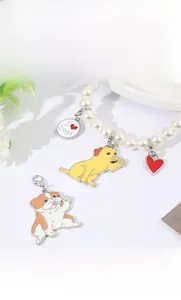 Dettaglio del portachiavi di perle con ciondoli a cane in smalto colorato e chiusura argento