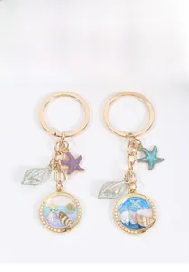 Détail d'un porte-clés nautique avec pendentif en résine, coquillage et étoile de mer