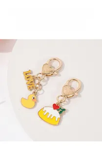 Detail of gold-plated duck and cake pendants on heart-shaped metal keychains