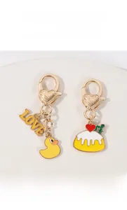 Detail of cartoon duck and pudding charms with heart-shaped metal carabiner keychains
