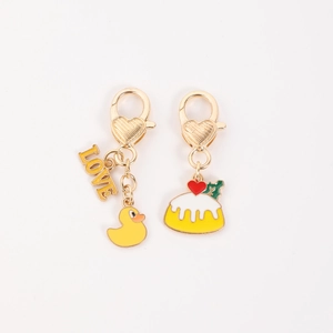 Detail of heart-shaped lobster clasps with yellow duck and love cake metal pendants