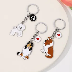 Trois porte-clés pour chien en émail avec breloques sur un plateau décoratif blanc