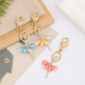 Détail de porte-clés ballerine avec jupes en cristal et strass sur monture dorée