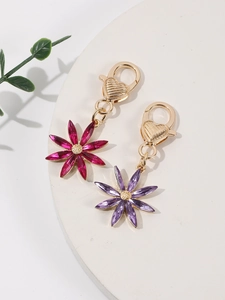 Détail de porte-clés fleurs à huit pétales en cristal rose et violet avec fermoirs coeur doré