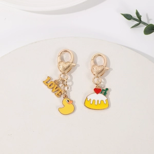 Detail of cartoon duck and love cake pendants with golden heart lobster clasps