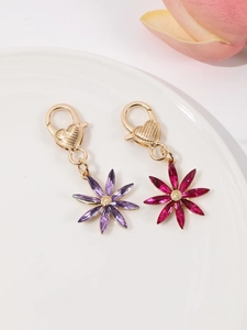Détail de breloques fleurs octogonales avec cristaux violets et fermoir en forme de cœur