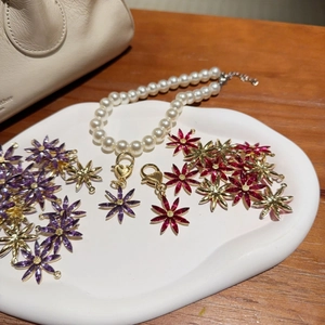 Pendentifs fleurs plaqués or et collier de perles en cristal violet et magenta