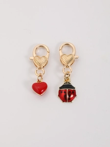 Détail du fermoir mousqueton en cœur avec pendentifs cœur rouge et coccinelle en émail