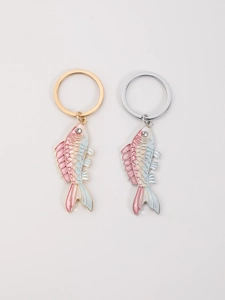 Detail of fish shaped enamel keychains featuring pink to blue gradient and crystal eye