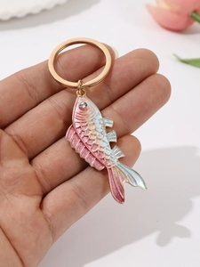 Macro shot of colorful gradient fish keychain with sparkling rhinestone eyes and gold ring