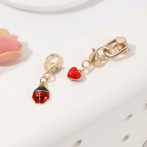 Lot de breloques cœur et coccinelle dorées avec émail rouge et fermoirs mousquetons