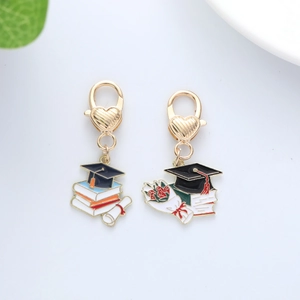 Golden graduation cap and diploma keychain set with heart-shaped lobster clasps