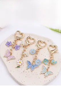 Detail view of four butterfly and flower metal keychains with colorful enamel finish