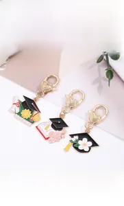 Detail showing graduation themed enamel charms with hearts clasp and metal graduate scroll
