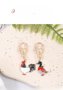 Detail of colorful enamel rooster and duck charms with golden heart lobster clasps