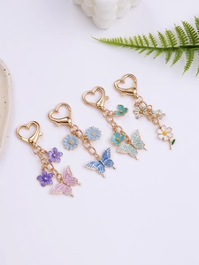 Detailed close-up of colorful butterfly and flower enamel keychains with heart-shaped clasps