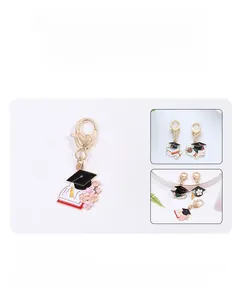 Detail of graduation keychain with enamel mortarboard, book charms and gold heart clasp
