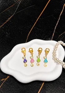 Detalle de cuatro dijes de gato en esmalte colorido con cierres de langosta de corazón dorado