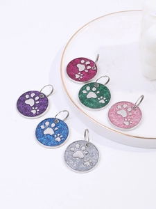 Close-up of glittery round pet ID tags with silver paw prints in six vibrant colors
