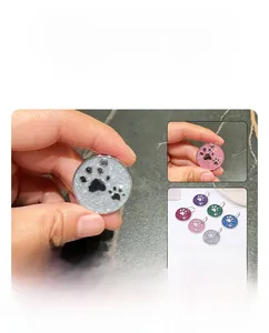 Detail of glitter zinc alloy pet ID tags featuring paw prints in various vibrant colors