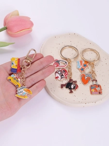 Vue macro détaillée de porte-clés en émail avec pendentifs de taxi et de valise