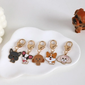 Detail of 5 dog enamel keychains with heart-shaped lobster clasps in a white ceramic dish