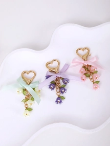 Detail of sweet floral keychains with heart clasps and lily of the valley petals