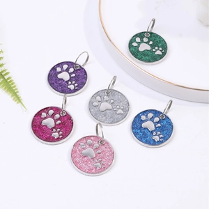 Set of colorful glitter pet ID tags with paw prints in blue, pink, and silver metal