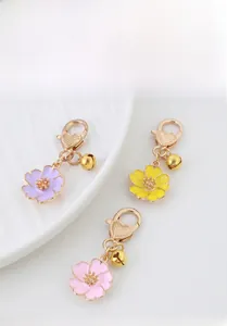 Close-up of alloy cherry blossom floral keychains with heart clasps and small bells