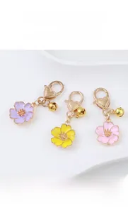 Close-up of cherry blossom keychains with heart clasps in purple, yellow, and pink colors