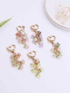 Flat lay of colorful heart-shaped keychains with translucent petals and butterfly charms