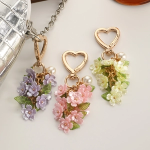 Detail of sweet floral bag charm with resin flower petals and heart lobster clasp