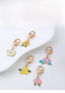 Detailed close-up of five colorful enamel flower charms with heart-shaped metal clasps
