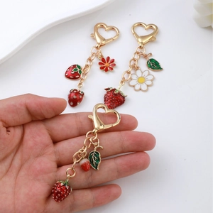 Three strawberry charms with daisy and heart lobster clasp on gold metal keychain