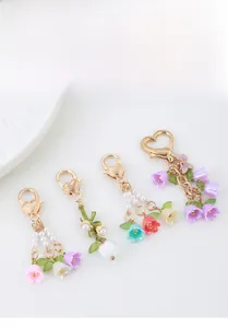 Detail showing lily of the valley keychains with colorful enamel petals and gold lobster clasps